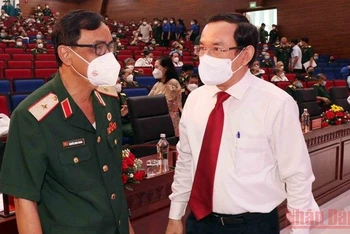 Ủy viên Bộ Chính trị, Bí thư Thành ủy TP Hồ Chí Minh Nguyễn Văn Nên trao đổi với các đại biểu tham dự buổi họp mặt. 