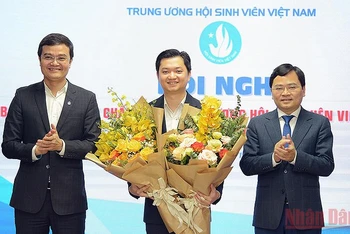 Các đồng chí Nguyễn Anh Tuấn (bên phải trong ảnh) và Bùi Quang Huy (bên trái trong ảnh) tặng hoa chúc mừng đồng chí Nguyễn Minh Triết nhận nhiệm vụ mới.