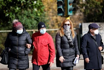 Người dân đeo khẩu trang đi bộ trên đường phố Rome, khi vùng Lazio ra quy định bắt buộc phải đeo khẩu trang ở tất cả các khu vực ngoài trời, Rome, Italia, ngày 23/12/2021. (Ảnh: Reuters)