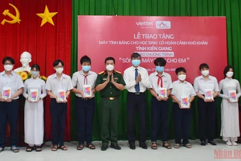 Ông Nguyễn Lưu Trung, Phó Chủ tịch UBND tỉnh Kiên Giang (thứ 5 từ phải sang) trao tặng máy tính bảng cho đại diện các em học sinh.