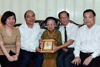 Chủ tịch nước Nguyễn Xuân Phúc thăm và tặng quà bà Nguyễn Thị Tú, mẹ liệt sĩ Nguyễn Thái Lai. (Ảnh: Thống Nhất/TTXVN)