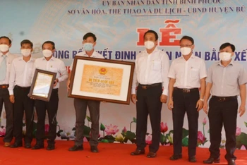 Lãnh đạo Sở Văn hóa, Thể thao và Du lịch tỉnh Bình Phước trao bằng xếp hạng Di tích lịch sử quốc gia địa điểm thảm sát ở Bù Đốp (16/3/1978) cho đại diện địa phương.