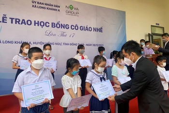 Đại diện Tập đoàn Novaland trao học bổng Cô giáo Nhế cho các em học sinh xã Long Khánh (Hồng Ngự, Đồng Tháp).