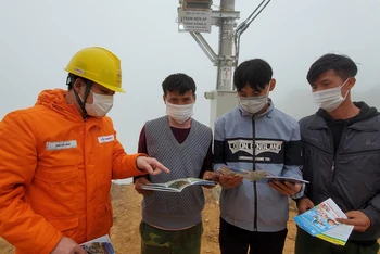 Cán bộ Điện lực Sơn La hướng dẫn người dân xã Chiềng Kheo cách sử dụng điện tiết kiệm.
