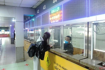 Hành khách mua vé xe tại bến xe Nước Ngầm, quận Hoàng Mai. (Ảnh: ĐĂNG KHOA)