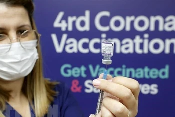 Tiêm vaccine ngừa Covid-19 liều thứ 4 cho những người trên 60 tuổi và đội ngũ nhân viên y tế tại Tel Aviv, Israel. (Ảnh: AFP/TTXVN)