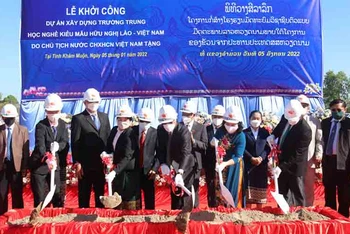 Các đại biểu Việt Nam và Lào thực hiện nghi thức xúc cát, khởi công công trình. (Ảnh: Xuân Sơn)
