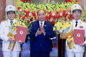 Chủ tịch nước Nguyễn Xuân Phúc trao Quyết định thăng cấp bậc hàm từ Trung tướng lên Thượng tướng đối với Thứ trưởng Công an Trần Quốc Tỏ và Lương Tam Quang. (Ảnh: Thống Nhất/TTXVN)