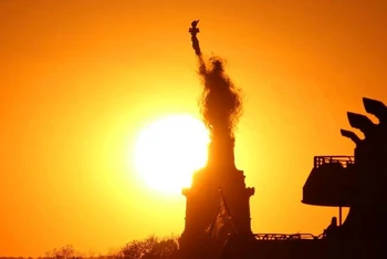 Mặt trời lặn đằng sau Tượng Nữ thần Tự do ở New York, Mỹ, tháng 5/2020. (Ảnh: AFP KEY FACTS)