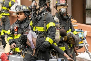 Lính cứu hỏa sơ tán các em nhỏ tại hiện trường vụ hỏa hoạn nghiêm trọng ở khu Tremont, quận Bronx, thành phố New York (Mỹ) ngày 9/1/2022. (Ảnh: Nydailynews.com/TTXVN)