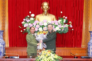Bộ trưởng Tô Lâm tặng hoa chúc mừng Bộ trưởng Vilay Lakhamphong. (Ảnh: Bộ Công an)