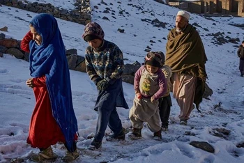 Người vô gia cư đi dưới tuyết lạnh ở Afghanistan. (Ảnh: UN)
