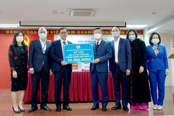 Lãnh đạo Liên đoàn Lao động thành phố Hà Nội tặng quà Trung tâm kiểm soát bệnh tật thành phố. (Ảnh: LĐ)
