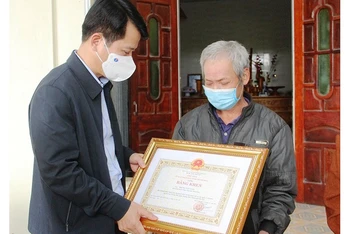 Trưởng Ban Tuyên giáo Tỉnh ủy Thanh Hóa trao Bằng khen cho đại diện gia đình anh Nam.