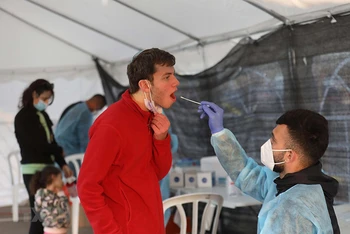 Nhân viên y tế lấy mẫu xét nghiệm Covid-19 cho người dân tại Modiin, Israel ngày 10/1. (Ảnh: THX/TTXVN)