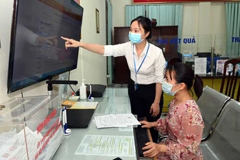 Hướng dẫn người dân thực hiện dịch vụ công trực tuyến tại phường Trung Hòa, quận Cầu Giấy, Hà Nội (Ảnh: DUY LINH)