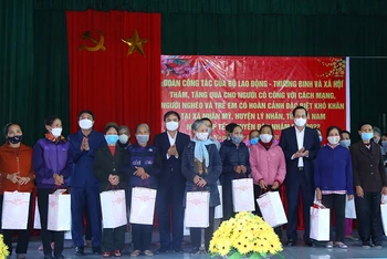Bộ trưởng Đào Ngọc Dung, lãnh đạo tỉnh Hà Nam tặng quà gia đình chính sách, hộ nghèo tại chương trình. (Ảnh: Molisa)