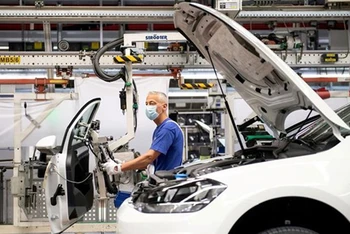Công nhân làm việc trên dây chuyền lắp ráp xe ô tô của Hãng Volkswagen ở Wolfsburg (Đức). (Ảnh: Reuters/TTXVN)