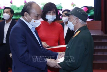 Chủ tịch nước Nguyễn Xuân Phúc tặng quà Tết cho các đối tượng chính sách. (Ảnh: TTXVN)