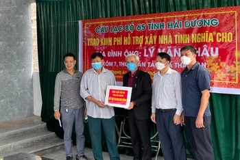 Đại diện câu lạc bộ 65 trao tặng kinh phí hỗ trợ xây nhà tình nghĩa cho anh Lý Văn Châu.