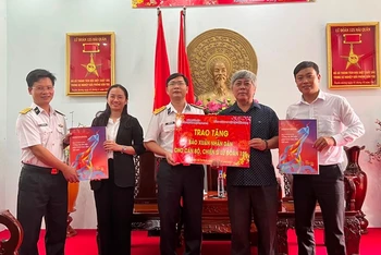Đại diện Cơ quan Thường trực Báo Nhân Dân tại TP Hồ Chí Minh và đại diện Tổng Công ty Điện lực Miền Nam trao tặng báo Xuân Nhân Dân 2022 cho cán bộ, chiến sĩ Lữ đoàn 125 Hải quân.