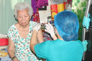 Tiêm vaccine tại nhà cho người già yếu, di chuyển khó khăn ở quận 10, Thành phố Hồ Chí Minh trong dịp Tết Nguyên đán 2022.