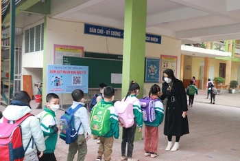 Kiểm tra thân nhiệt cho học sinh tại Trường Tiểu học Hồng Sơn (TP Vinh). (Ảnh: Mỹ Hà)