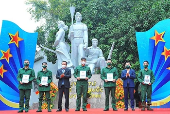 Đồng chí Nguyễn Anh Tuấn (thứ 2 từ phải sang trong ảnh) và đại diện lãnh đạo thành phố Hà Nội trao sổ tiết kiệm tặng thanh niên tình nguyện lên đường nhập ngũ có hoàn cảnh khó khăn.