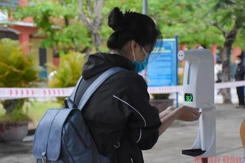 Học sinh khối 8 Trường THCS Phạm Ngọc Thạch (quận Sơn Trà, Đà Nẵng) đo thân nhiệt, rửa tay sát khuẩn trước khi vào lớp.