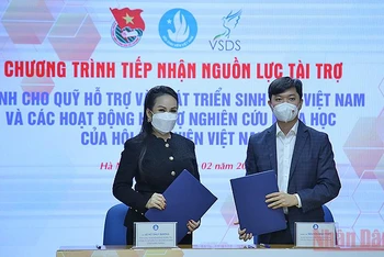 Bí thư Trung ương Đoàn, Chủ tịch Hội Sinh viên Việt Nam Nguyễn Minh Triết trao đổi biên bản cam kết tài trợ cho Quỹ Hỗ trợ và Phát triển sinh viên Việt Nam từ bà Lê Nữ Thùy Dương.