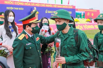 Phó Chủ nhiệm Tổng cục Chính trị Quân đội nhân dân Việt Nam Trịnh Văn Quyết tặng hoa các tân binh.