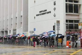 Người dân đội mưa xếp hàng chờ xét nghiệm Covid-19 ở Hồng Kông, Trung Quốc, ngày 19/2/2022. (Ảnh: REUTERS)