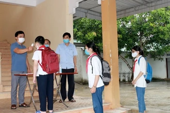 Học sinh ở các trường học trên địa bàn thành phố Vinh kiểm tra nhiệt độ trước khi vào lớp.