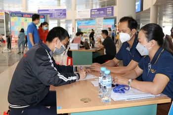 Anh Nguyễn Hoàng Hiệp (bên trái) đăng ký thông tin với nhà tuyển dụng.