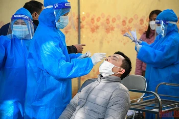 Nhân viên y tế quận Hoàng Mai lấy mẫu xét nghiệm Covid-19 cho các F0 tại Nhà văn hóa phường Hoàng Liệt. (Ảnh: THÀNH ĐẠT) 