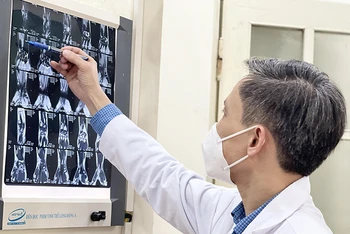 PGS,TS Nguyễn Mạnh Khánh xem hình ảnh MRI của bệnh nhân trước khi tiến hành phẫu thuật nội soi. 