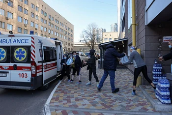 Nhân viên Bệnh viện Nhi Okhmadet tại Kiev, Ukraine, chuyển nước từ xe cứu thương, ngày 28/2. (Ảnh: Reuters)