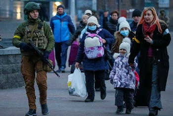 Quân nhân hỗ trợ những người có con nhỏ rời Bệnh viện Nhi trung ương tại Kiev lên chuyến tàu sơ tán tới Lviv, ngày 7/3. (Ảnh: Reuters)