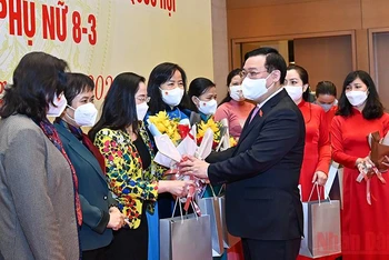 Chủ tịch Quốc hội Vương Đình Huệ tặng hoa, tặng quà chúc mừng các nữ đại biểu. (Ảnh: DUY LINH)