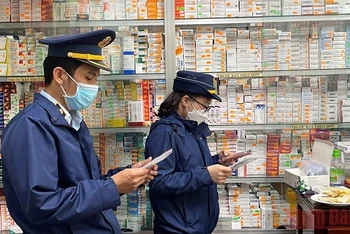 Lực lượng chức năng kiểm tra việc mua bán trang thiết bị y tế tại một quầy thuốc ở thành phố Quảng Ngãi.