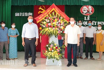 Đồng chí Mai Văn Tuất, Trưởng Ban Tổ chức Tỉnh ủy tặng hoa chúc mừng thành lập Chi bộ HTX chăn nuôi thủy sản Sông Đằng tháng 6/2021 (xã Yên Đồng, huyện Yên Mô). Ảnh: Thái Học