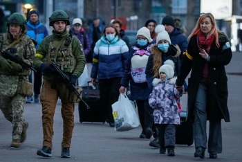Các binh sĩ hộ tống bệnh nhi và người nhà từ Bệnh viện Nhi Trung ương Kiev đi sơ tán, Kiev, Ukraine, ngày 7/3/2022. (Ảnh: REUTERS)