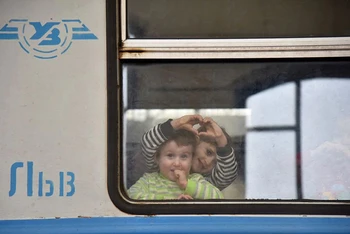 Những trẻ em được sơ tản nhìn ra cửa sổ toa tàu tại một nhà ga ở Lvov, Ukraine, ngày 9/3/2022. (Ảnh: REUTERS)