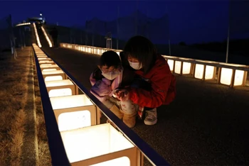 Người dân Nhật Bản thắp đèn tưởng nhớ nạn nhân của thảm họa động đất, sóng thần cách đây 11 năm. (Ảnh: Kyodo)