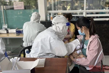 Phụ huynh đưa trẻ đi khám do nghi ngờ mắc Covid-19 tại Bệnh viện Nhi Đồng 2.
