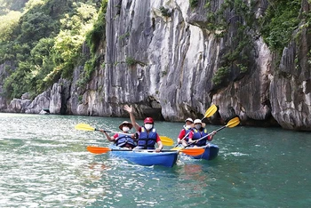 Khách du lịch quốc tế trong tour du lịch tham quan chèo thuyền kayak tại Vịnh Hạ Long. (Ảnh NGHĨA HIẾU)