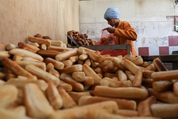 Thợ làm bánh gói những ổ bánh mì vào túi nilon tại 1 tiệm bánh ở Sanaa, Yemen, ngày 1/3/2022. (Ảnh: REUTERS)