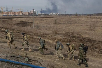 Các binh sĩ Ukraine di chuyển tại khu vực giao tranh ở Irpin, ngoại ô Kiev, Ukraine, ngày 12/3/2022. (Ảnh: REUTERS)
