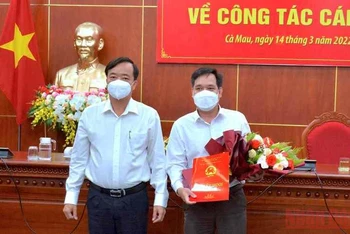 Chủ tịch Ủy ban nhân dân tỉnh Cà Mau (bìa trái) trao quyết định và tặng hoa chúc mừng tân Chánh Văn phòng Ủy ban nhân dân tỉnh.