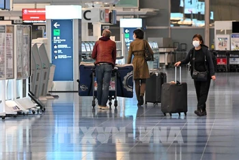 Hành khách tại sân bay Haneda ở thủ đô Tokyo, Nhật Bản, ngày 1/12/2021. (Ảnh: AFP/TTXVN)